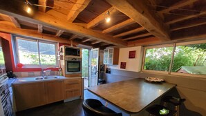 A kitchen with wooden cabinets, a built-in oven, a sink, and a bar stool. - The house patio of Velleron (Velleron)