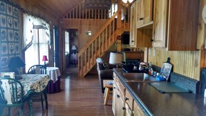 Un interior de madera con comedor, cocina y escalera.