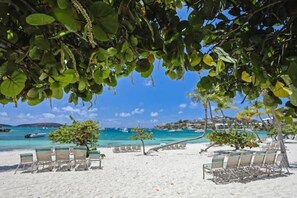 Une plage de sable blanc, avec des chaises longues et une vue sur la mer.