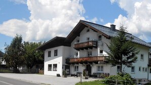 A two-story building with a balcony, a sign reading "Hotel Danis," and a mountainous backdrop.