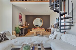 A modern living room with a sofa, a coffee table, a fireplace, and a spiral staircase. - Stunning Private Wine Country Estate - Epic Views - Pool - Hot Tub - Sunsets! (Sonoma)