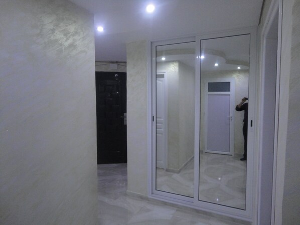A hallway with a glass door leading to a room. - Apartment Akid Lotfi Oran + wi-fi  (Bir El Djir)
