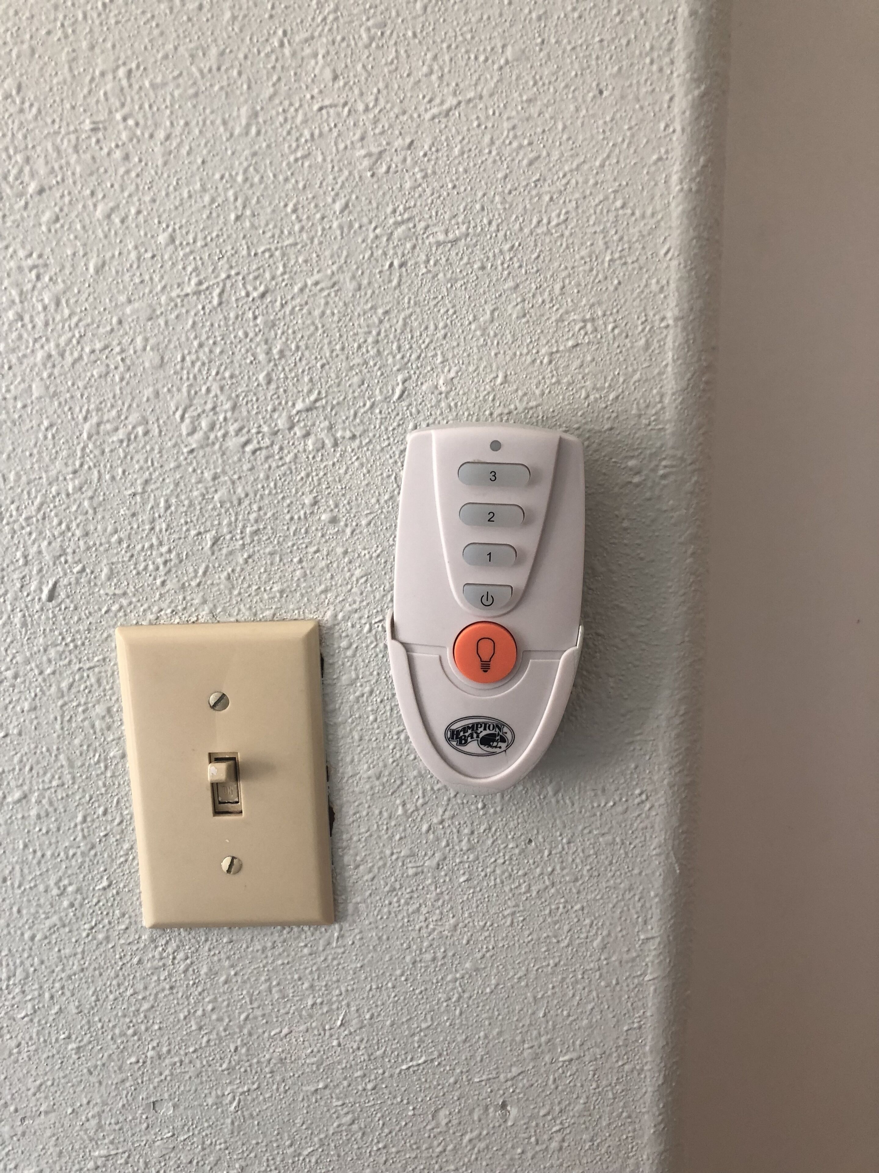 A wall-mounted control panel with a switch and a button.
