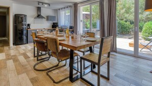 Una cocina moderna con comedor, ventanas amplias y vistas al exterior.