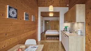 A wooden interior with a kitchen, dining area, and a bed. - Sunny apartment in an ideal location to Lake Kaltern, historic village (Kaltern)