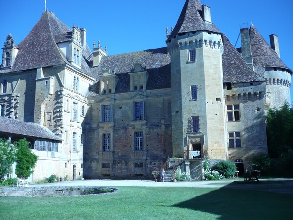 Un bâtiment historique doté de plusieurs tours et d’une cour intérieure.