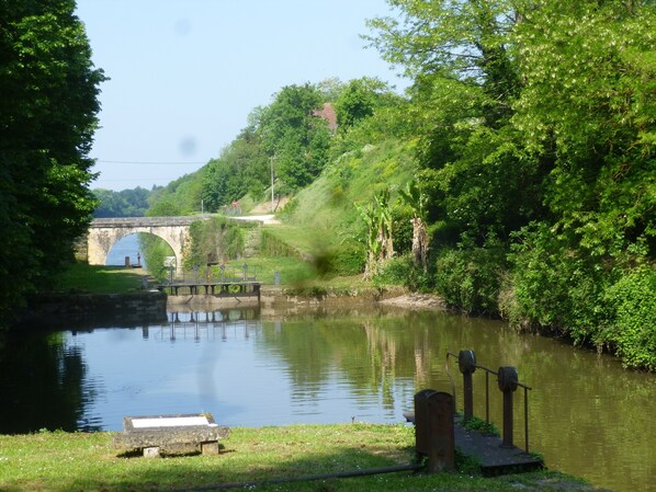 A stone bridge over a calm river, surrounded by lush greenery and a clear sky. - All the charm of Périgord ...holiday house near Bergerac with your pets (Lanquais)