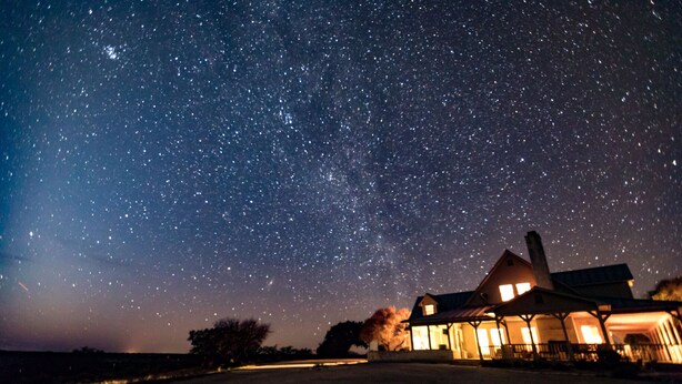 A house with a porch under a starry night sky. - Hill Country Getaway with great views (Mountain Home)