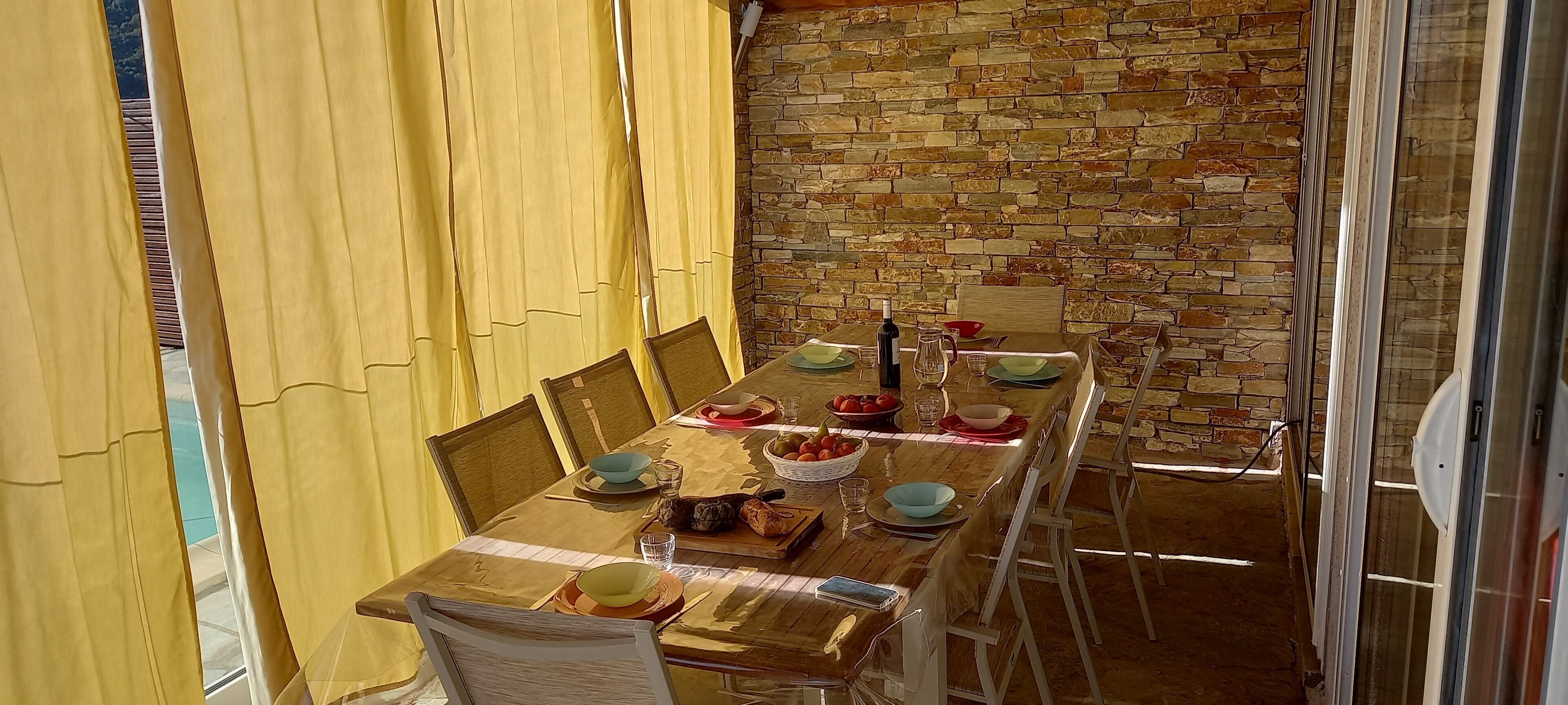 A dining area with a brick wall, wooden table, and chairs.