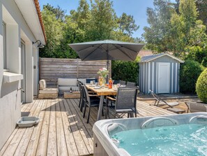A wooden deck with a hot tub, outdoor seating, and a covered table area. - Villa Russie - Domaine Le Sherwood (Notre-Dame-De-Monts)