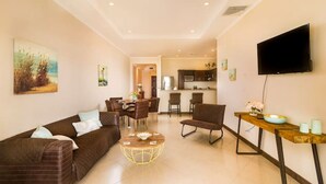 Ein modernes Wohnzimmer mit Sofa, Couchtisch und Essbereich.
