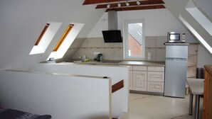 A kitchen with a built-in microwave, a refrigerator, and a window above the sink. - Apartment "Cockle" for 2P, at the North Sea between Dornumersiel and Bensersiel (Dornum)