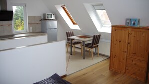A kitchen with a dining area, wooden cabinets, and skylights. - Apartment "Cockle" for 2P, at the North Sea between Dornumersiel and Bensersiel (Dornum)
