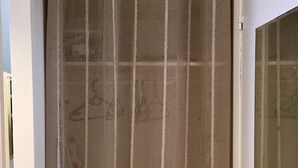 Ein Zimmer mit einer Schiebetür und einem gemusterten Vorhang.