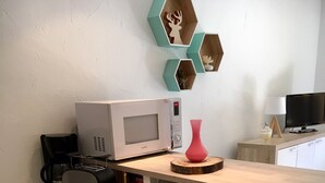Eine kleine Küchenzeile mit Mikrowelle, Toaster und Kaffeemaschine.