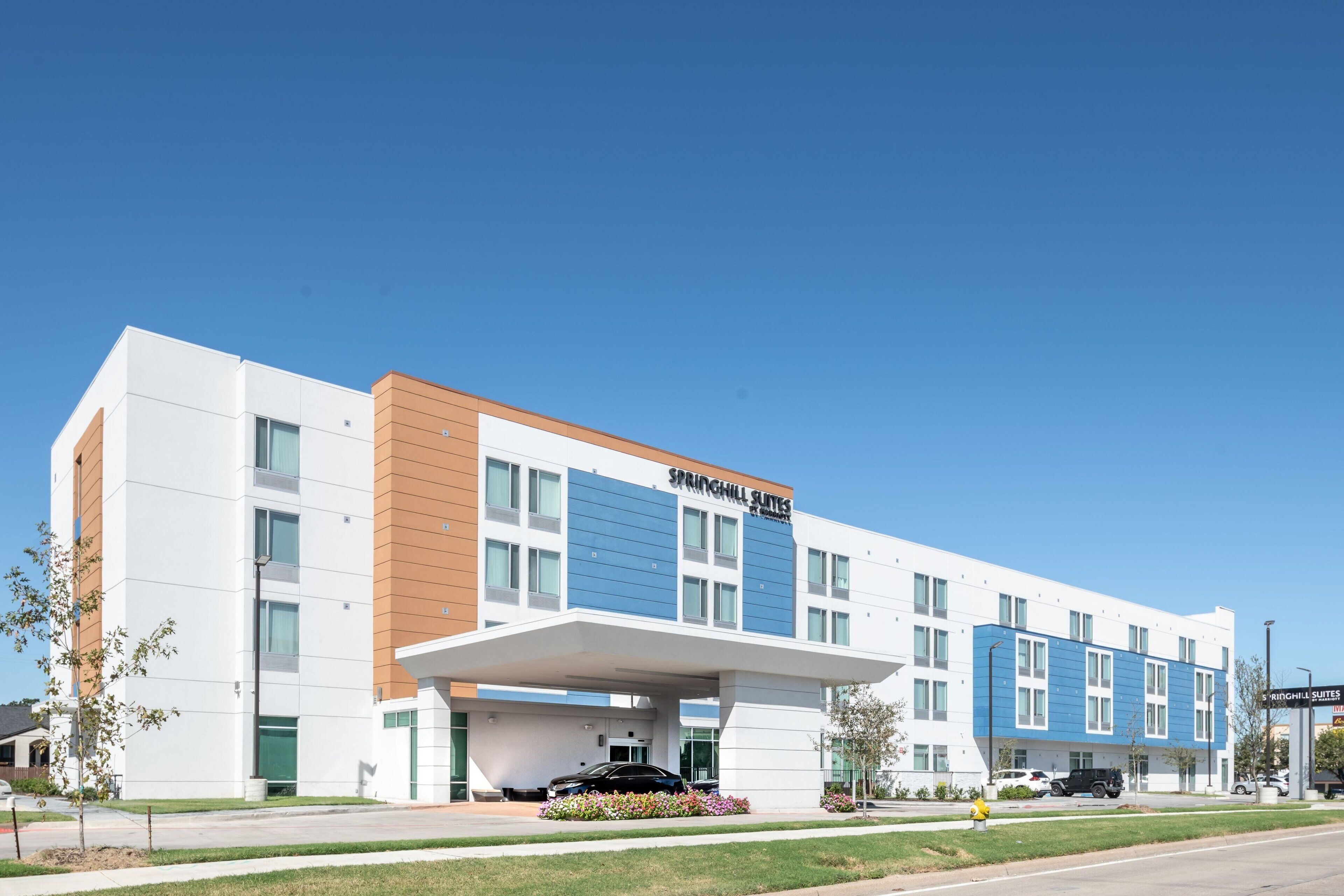 A modern hotel with a flat roof, large windows, and a sign reading "SPRINGHILL SUITES."