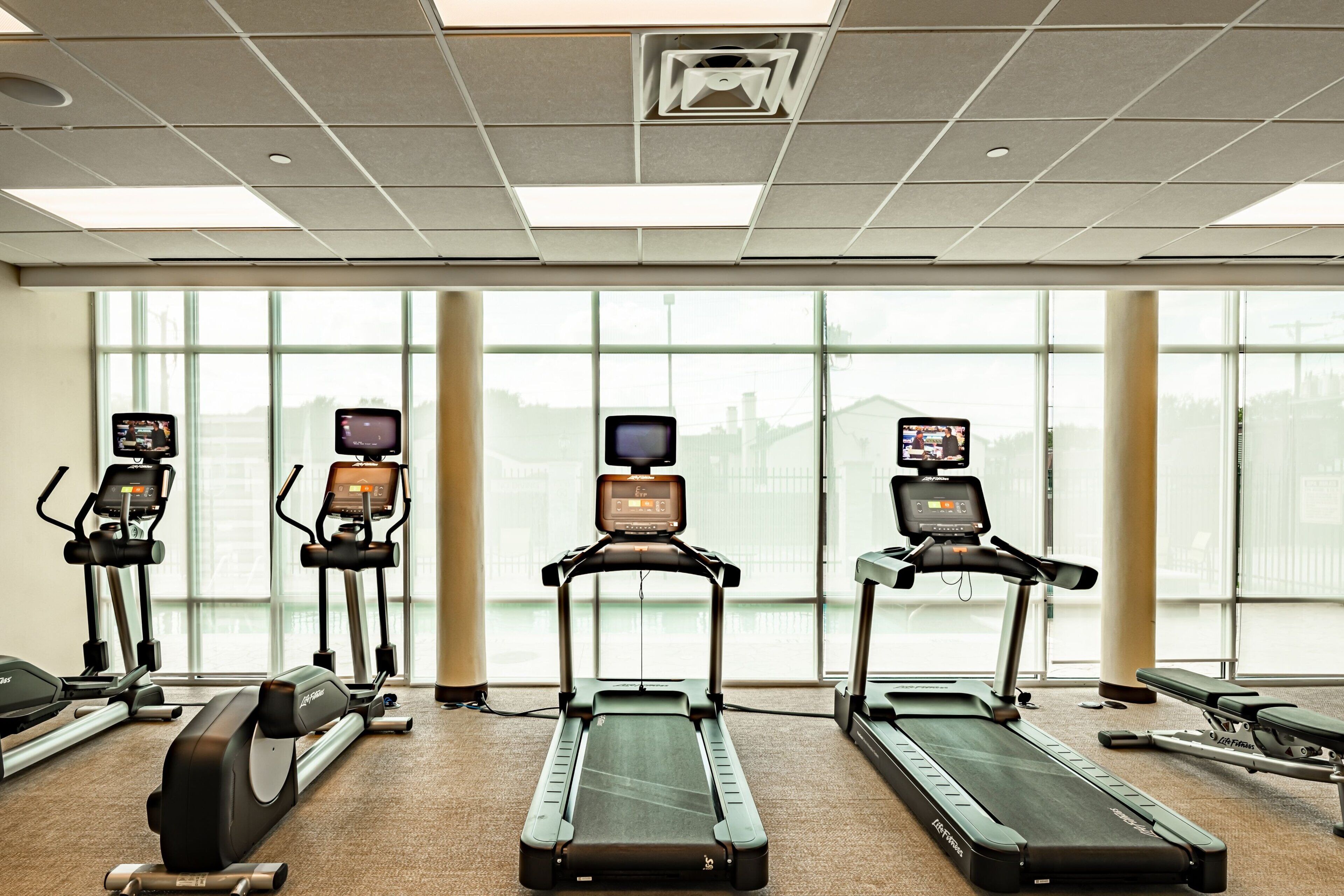 A gym with treadmills, ellipticals, and a rowing machine.