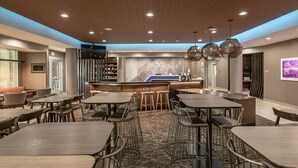 Un restaurant moderne doté d’un bar, d’un plafond en bois et de mobilier contemporain.