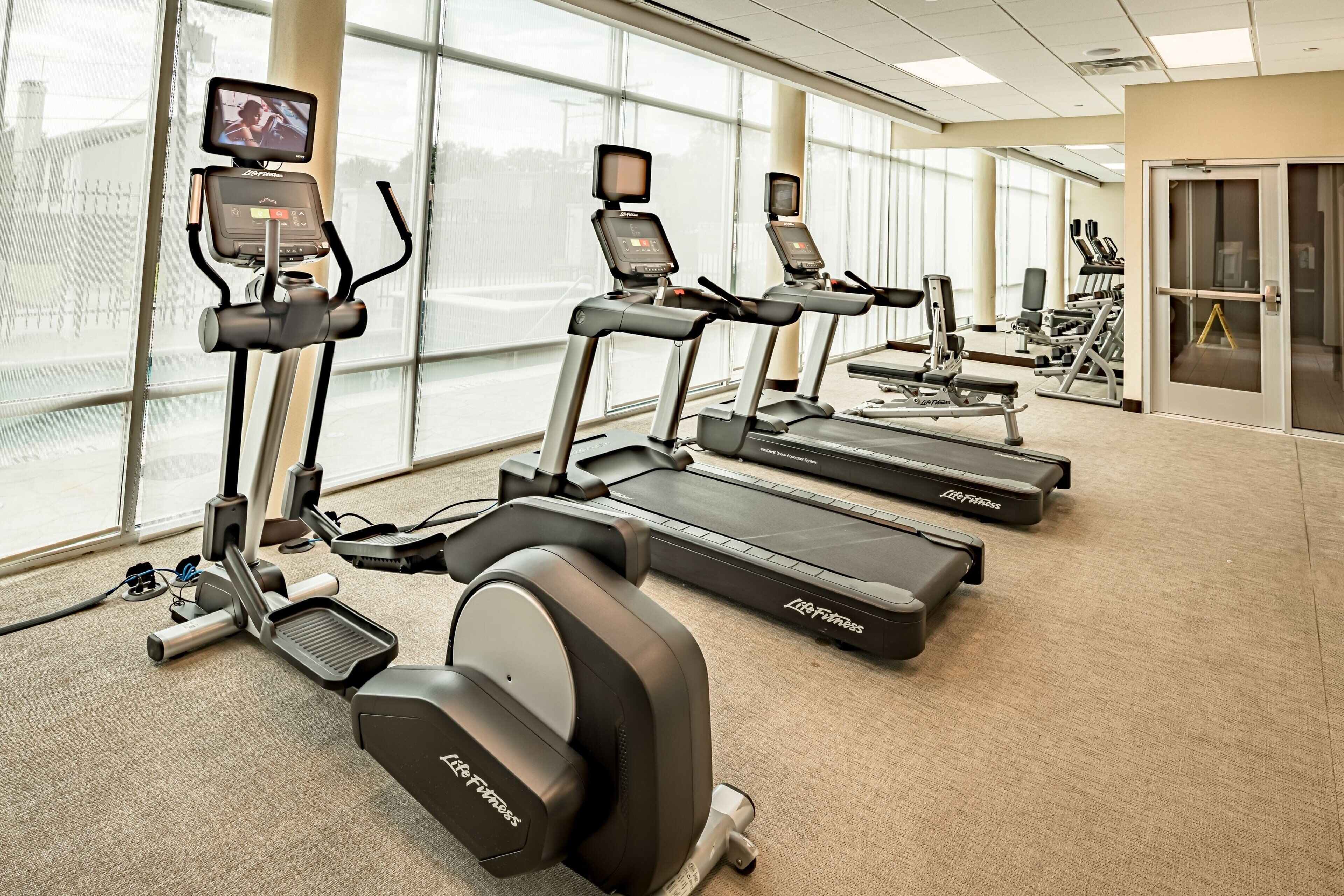 Une salle de sport équipée de tapis de course, de vélos d’appartement et d’un appareil d’aviron, le tout doté d’écrans numériques et de moniteurs de fréquence cardiaque.