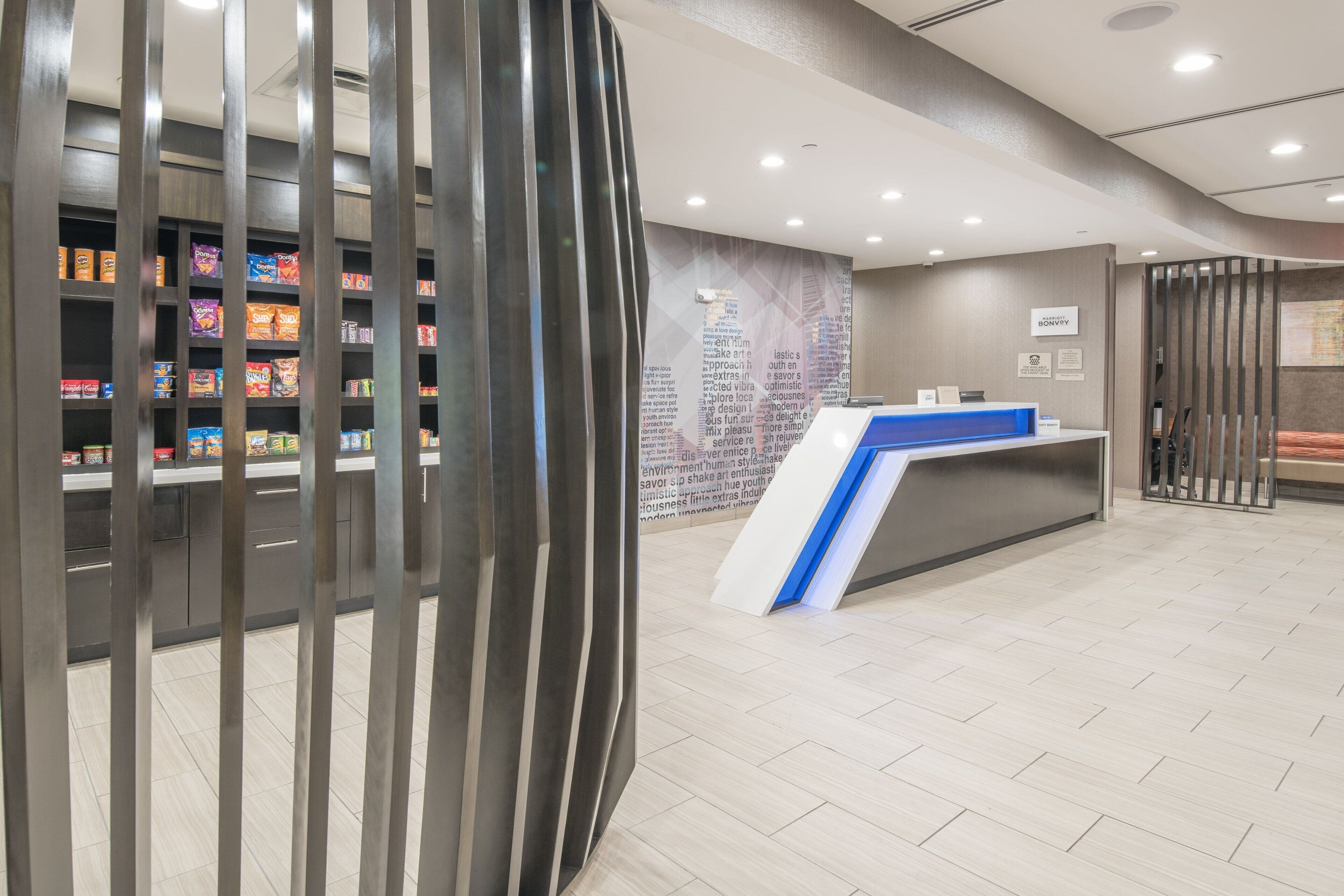 Un'area di accoglienza con un bancone, scaffali con snack e un design moderno.