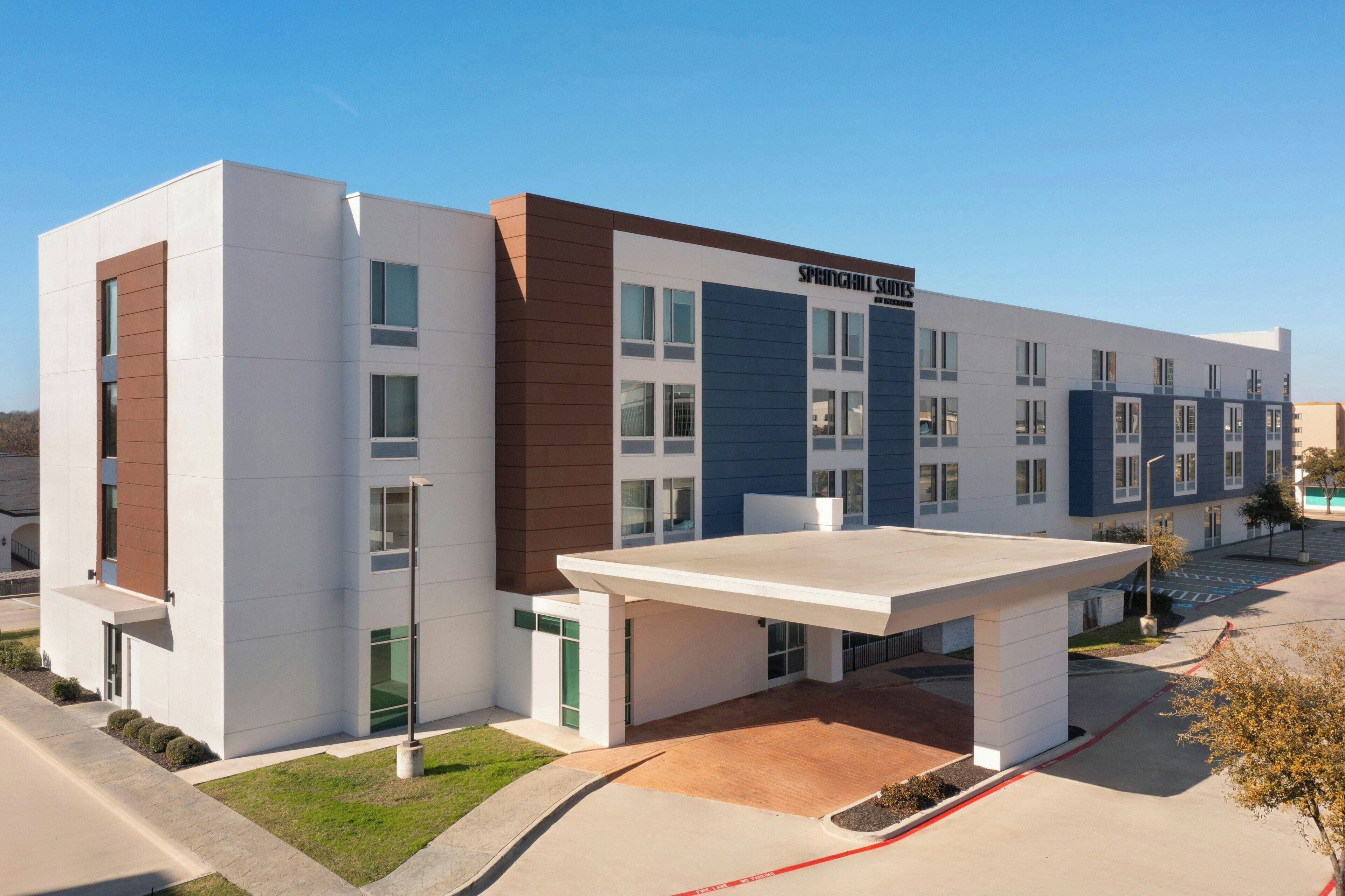 Un hotel moderno con techo plano, ventanas amplias y un cartel que dice "Springhill Suites".