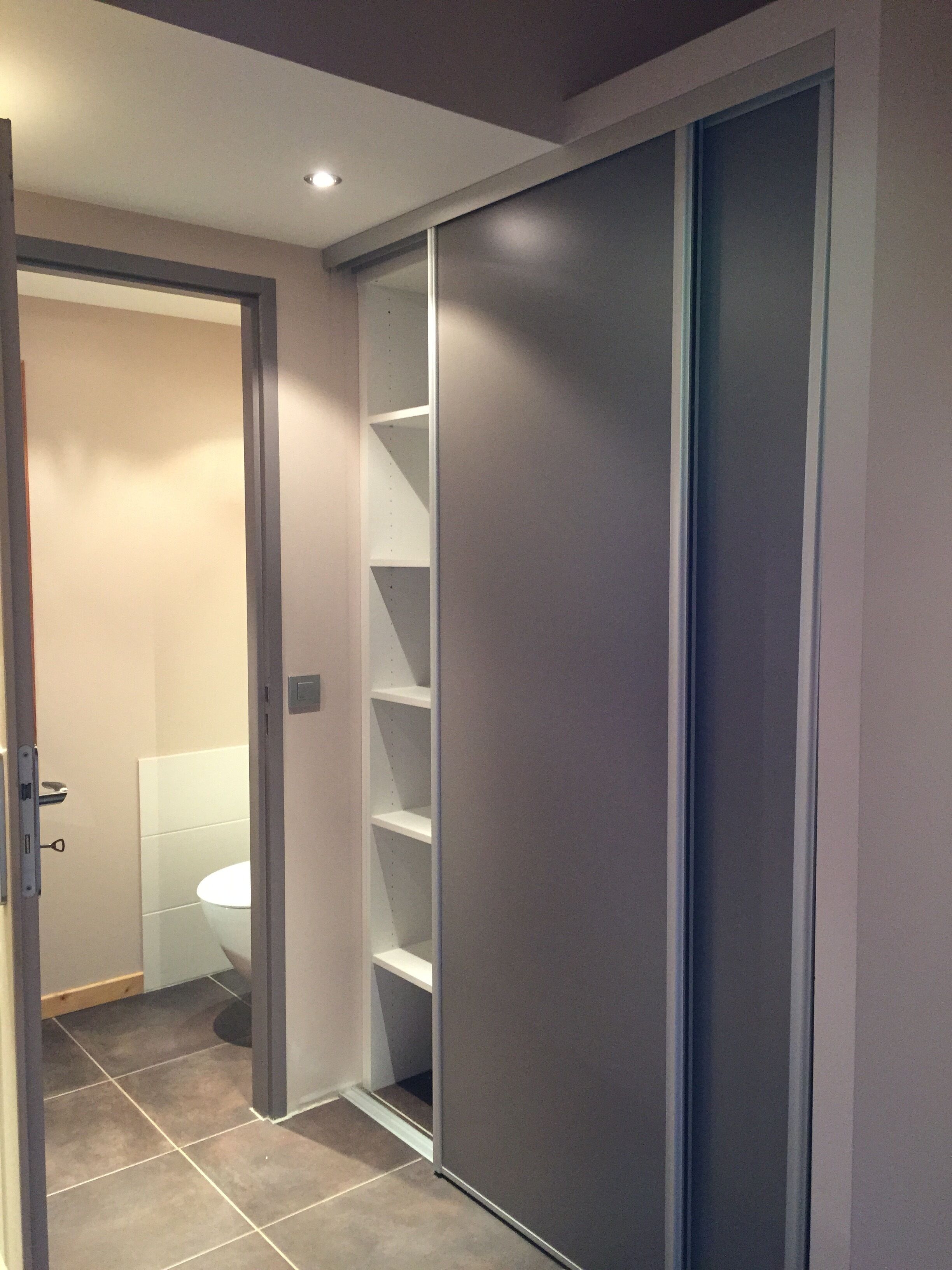 Une salle de bain moderne équipée de toilettes, d’une douche et d’un meuble de rangement.