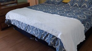 A bedroom with a bed, a dresser, a mirror, and two wall decorations. - Great Family Fun On The Emerald Coast In A Gated Resort. (Panama City Beach)