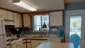 A compact kitchen with a central island, a microwave, a stove, and a sink. - Great Family Fun On The Emerald Coast In A Gated Resort. (Panama City Beach)