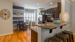 A modern kitchen with a granite countertop, dark cabinets, and a decorative bowl.