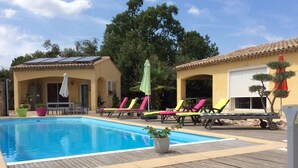 A swimming pool with lounge chairs and a wooden deck.
