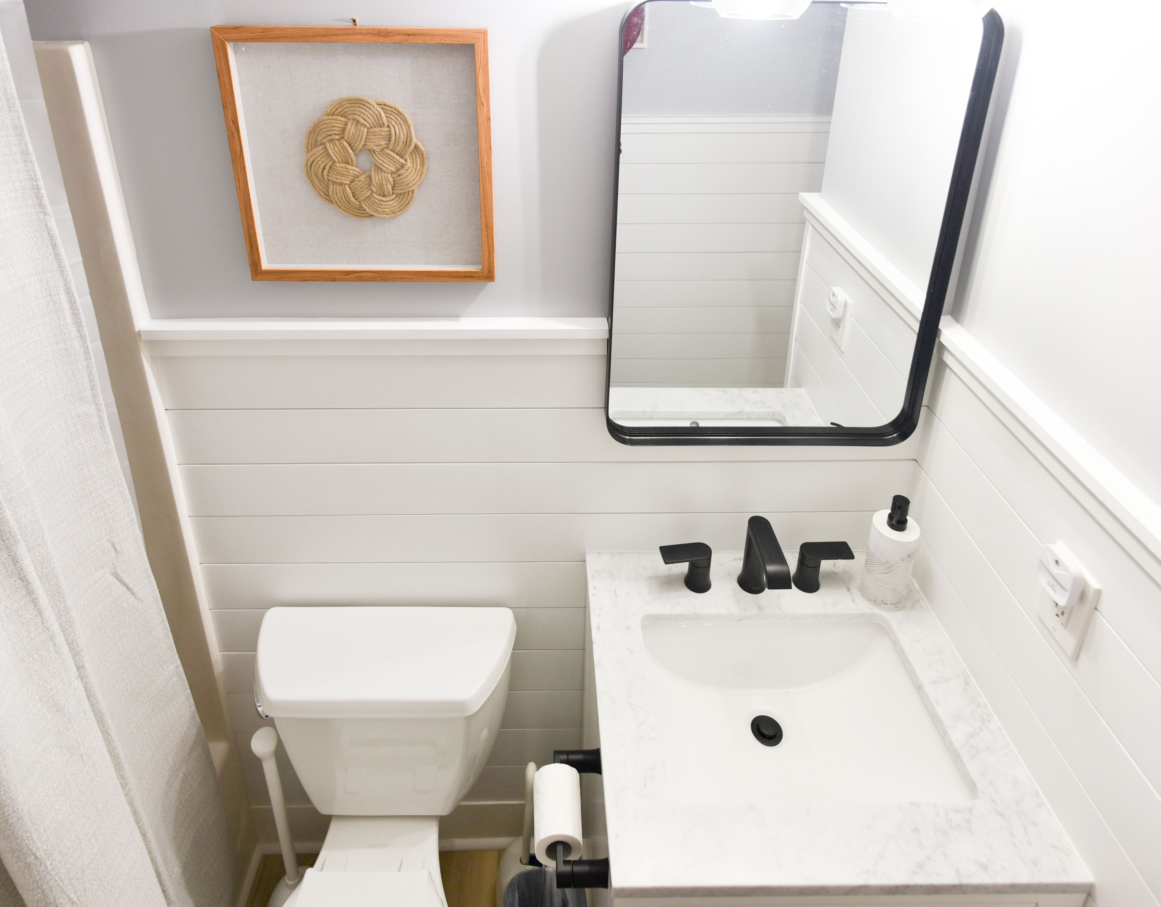 Une salle de bain avec des toilettes, un lavabo et un miroir.