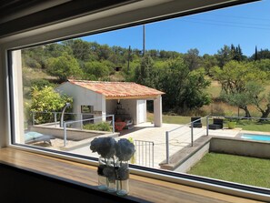 Vista de uma casa com um pátio, uma pequena piscina e um jardim.