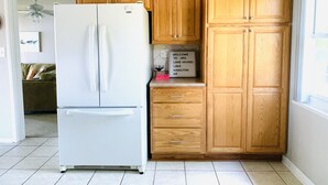 Una cucina con mobili in legno, un frigorifero bianco e un cartello di benvenuto.