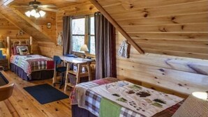 Uma cabana acolhedora com quarto no mezanino, área de jantar e pequena cozinha.