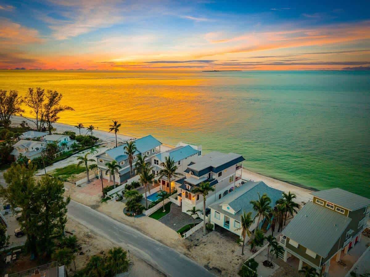 Une zone résidentielle côtière comprenant des maisons, une route et une plage.