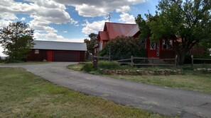 Une propriété rurale avec une grange rouge, un garage et un mur en pierre.