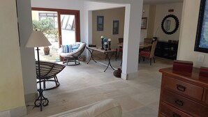 Uma sala de estar espaçosa com um sofá, uma mesa de jantar e um armário de madeira.