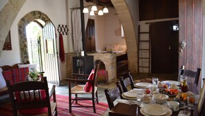 Un coin repas rustique avec des murs en pierre, des meubles en bois et une cheminée en pierre.
