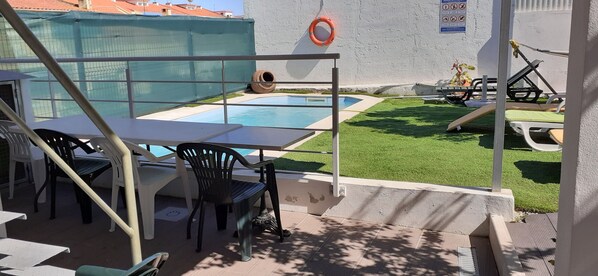 A pool area with a table and chairs, a slide, and a lifebuoy. - Rio ... Beaches ... Lisbon, Ideal for families with children and pets. (Almada)