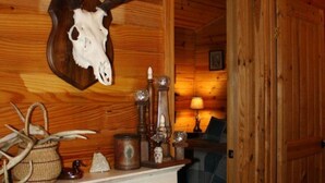 A rustic interior with a mounted deer skull, a fireplace, and wooden walls. - Morningstar Cabin Caddo River. GREAT VALUE!!!!!!!!!!! River access!! (Glenwood)