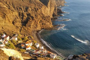Un pueblo costero con casas a lo largo del acantilado, con vista al mar.