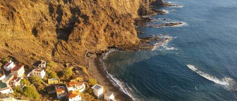 Un pueblo costero con casas a lo largo del acantilado, con vista al mar.