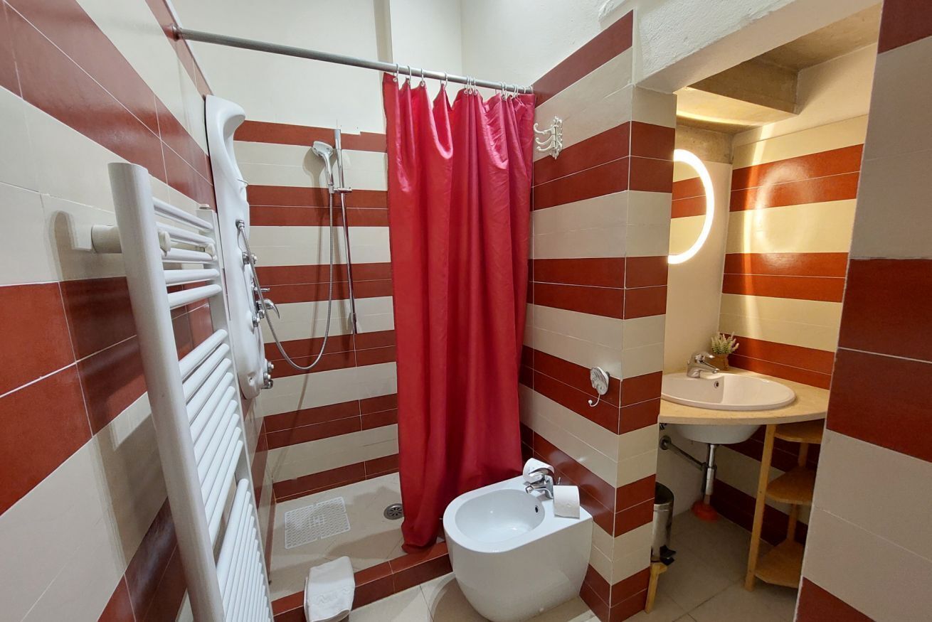 A bathroom with a shower, a bidet, and a sink.