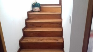 Una escalera de madera con una pequeña planta en el último escalón.