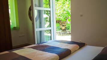 A bedroom with a large bed, a window, and a view of an outdoor area.