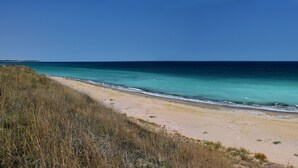 Una playa con aguas turquesas cristalinas y una orilla arenosa.