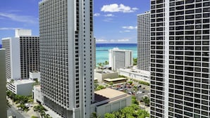 A high-rise hotel with multiple floors, a parking area, and a view of the ocean. - Diamond Head and Ocean View Waikiki Sunset! (WS06) (Honolulu)