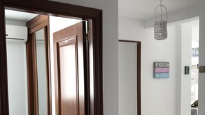 Ein Korridor mit einer Holztür, einer Deckenleuchte und einem motivierenden Zitat an der Wand.