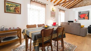 Un coin repas avec une table en bois, des chaises et un tapis à motifs.