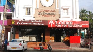 Un edifici amb un rètol que diu 'Le Emmanus Residency' i 'LOIEE Pure Veg Restaurant'.